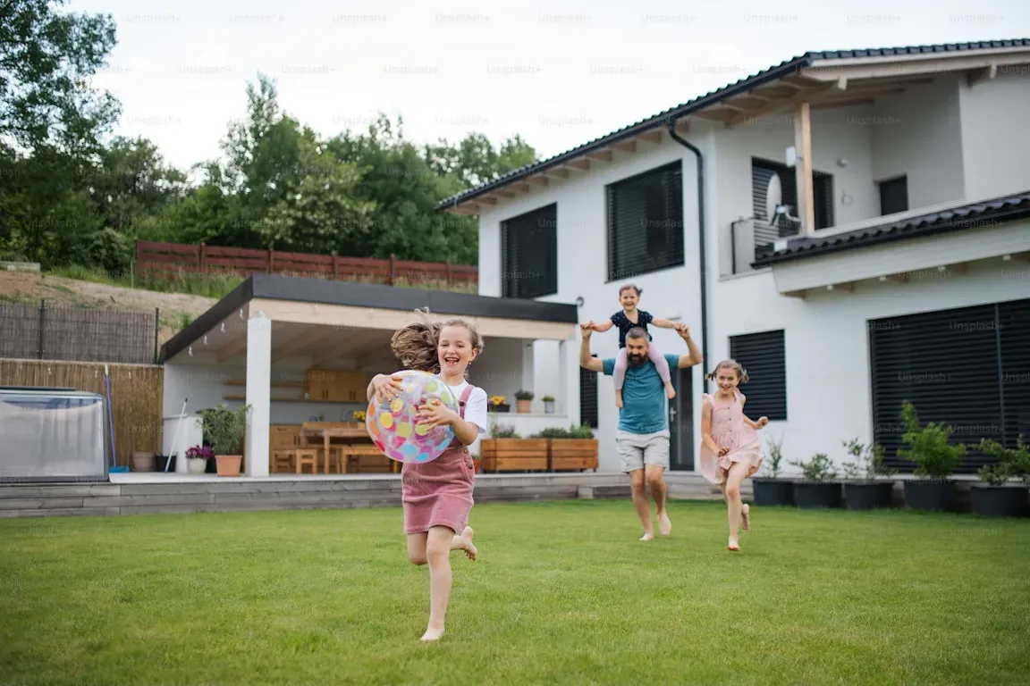 Family playing on the lawn behind their home