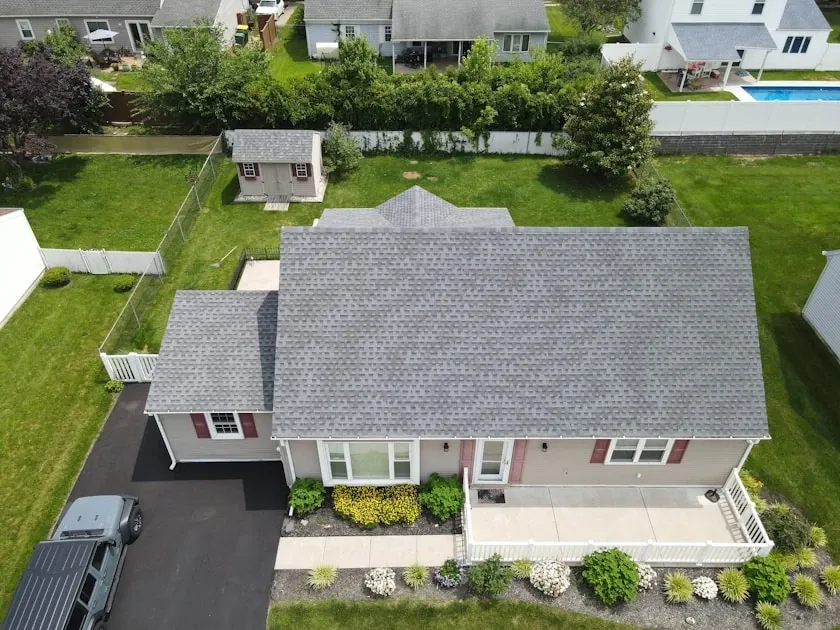 Aerial view of a suburban home with a new grey shingle roof