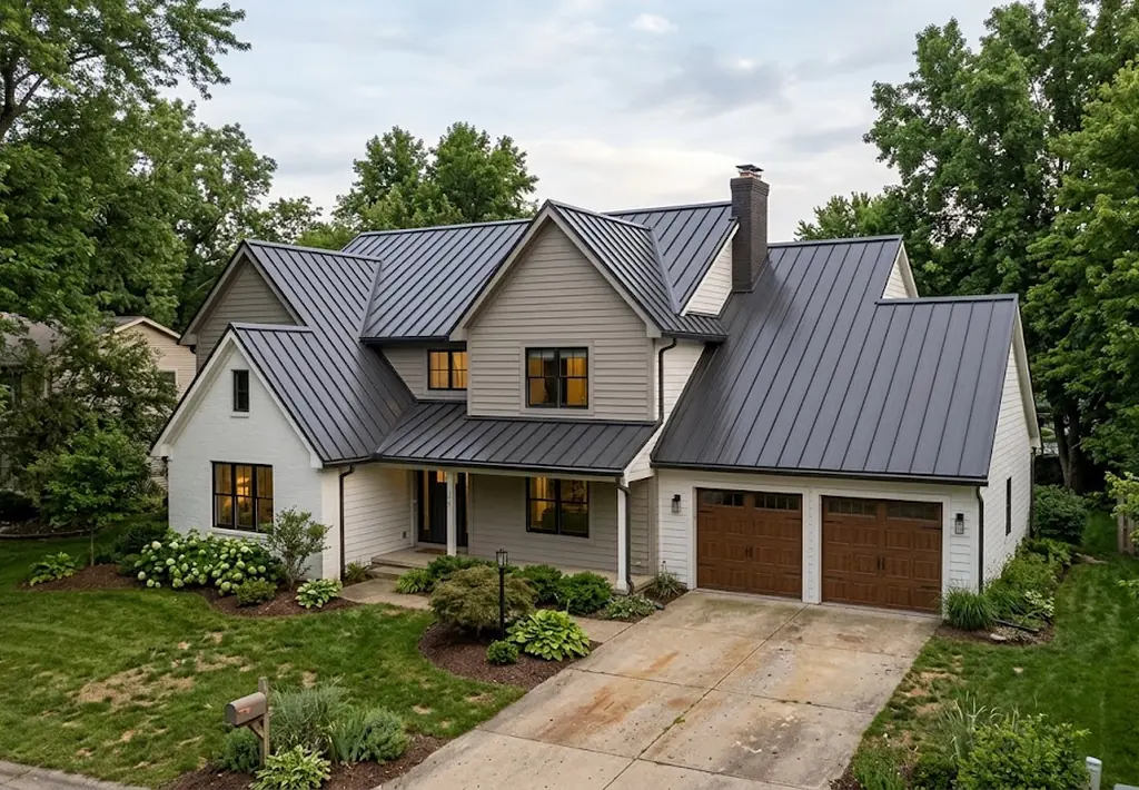 White Westlake home with a dark standing seam metal roof at dusk